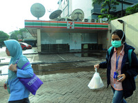 residents passing in front of 7 Eleven retail outlets are broke in glass cover with plastic and paper  in Jakarta Indonesia, on June 30,2017...