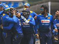 Sri Lankan cricketer wanidu hasaranga is hugged by Sri lankan team members after he completed taking a a hat-trick of wickets against Zimbab...
