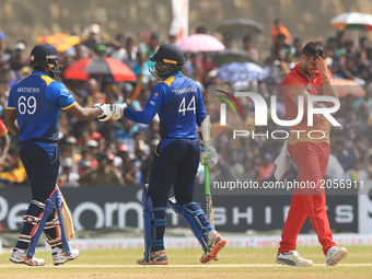 Sri Lankan cricket captain Angelo Mathews and Upul Tharanga tap their  gloves  as Zimbabwe captain Graeme Cremer(R) reacts during the 2nd On...