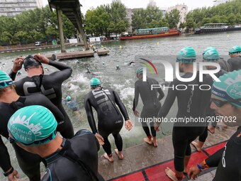 Competitors dive in the Bassin de La Villette during the swim section of the 2017 edition of the Paris triathlon on July 2. 2017 in Paris. A...