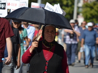 A woman is seen with an umbrella during a march to the 24th anniversary of the Sivas massacre in Ankara on July 02, 2017. In 1993, 35 people...