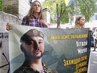 Ukrainian activists from National corps hold a poster with a portrait of Ukrainian soldier Vitaly Markiv, reading 