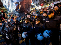 A  inflated cube out of aluminum is falling in policemen. About 20000 people demonstrated in a march with several music cars against the G20...