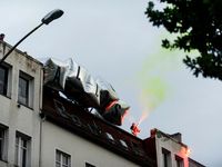 Activists use smoke grenades on a roof. About 20000 people demonstrated in a march with several music cars against the G20 summit. At the G2...