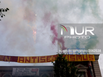 Activists hold smoke grenades in the air on the roof of the  autonomous center Rote Flora. About 20000 people demonstrated in a march with s...