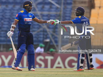 Sri Lankan cricketer Niroshan Dikwella (R) and teammate Danushka Gunathilaka congratulate each other during the third one-day international...