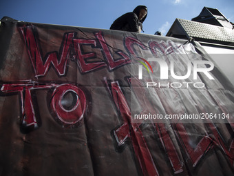 Protesters dressed in all black hold up a banner as they take part in the 'Welcome to Hell' protest march on July 6, 2017 in Hamburg, German...