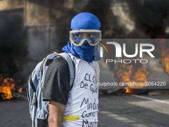 Oppositin activist waits for the police by the fire during a rally, in Caracas, Venezuela on July 6 2017. (