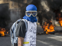 Oppositin activist waits for the police by the fire during a rally, in Caracas, Venezuela on July 6 2017. (