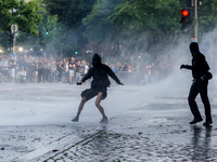 A demonstrator is hit by the water jet of a water cannon, in Hamburg, Germany, on July 7, 2017. In the evening there was a lot of riots in t...