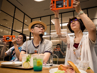 SENDAI, JAPAN - JULY 8: Anime fans holding a smart phone equipped with augmented reality (AR) application enjoying their virtual idol Hatsun...