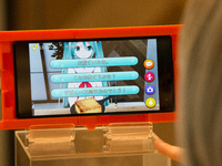 SENDAI, JAPAN - JULY 8: Anime fan looking at menu of a smart phone equipped with augmented reality (AR) application enjoying his virtual ido...