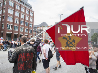 A man holding a red flag attend a protest march against the G20 Summit with the topic 'Solidarity without borders instead of G20' in Hamburg...