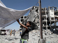Palestinian boy to prepare a tent in front of residential buildings badly damaged after returning from the town of Beit Lahiya  as the fragi...