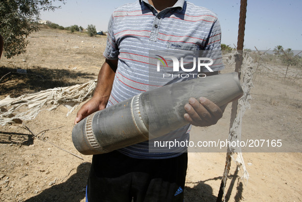A Palestinian man holds a the Projectile fired from an Israeli fly earlier in Rafah in the southern Gaza Strip, on August 6, 2014, while Isr...
