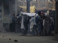 kashmiri people carrying the body of  local pro-independence fighter  Sajad Ahmed Gilkar  as they make there way through Tear smoke fired by...