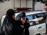 Relatives of nine Palestinians from the Abu Nejim family, whom medics said were killed by an Israeli air strike, mourn during their funeral...
