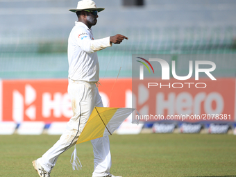  Sri Lankan cricketer  Angelo Mathews walks on with a kite that fell in to the playing area during the first day of the only Test cricket ma...