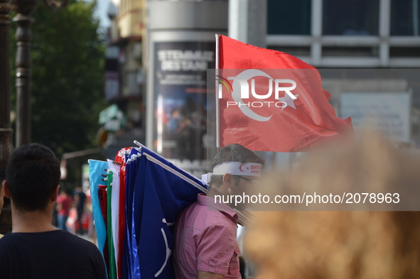 A Turkish flag waves as a man sells flags on the street in Ankara, Turkey on July 14, 2017. On July 15, 2016, Turkish military factions, whi...