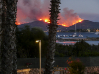 The forest burning seen by the seaside, in San Teodoro, Italy, on July 13, 2017. Tourists and locals have been forced to flee to beaches as...