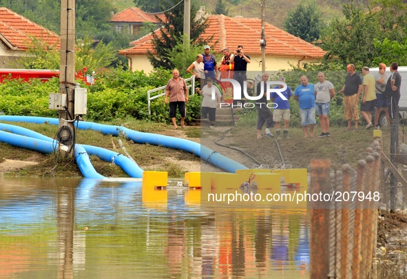 People try to save belongings, animals and pets in the flooded town of Mizia north-east of the Bulgarian capital Sofia , Wednesday, Aug, 06,...
