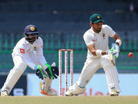 Zimbabwe cricketer  Sikandar Raza(R) plays a shot as Sri Lanka's wicket keeper Niroshan Dickwella looks on during the third day's play of th...
