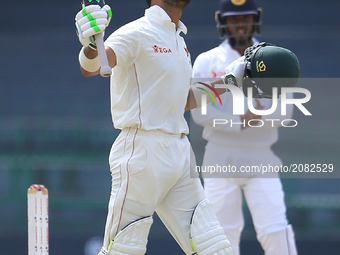 Zimbabwe cricketer Sikandar Raza raises his bat and look up at the sky after scoring 100 runs during the 4th day's play in the only Test mat...