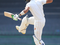 Zimbabwe cricketer Sikandar Raza leaps in the air in celebration after scoring 100 runs during the 4th day's play in the only Test match bet...