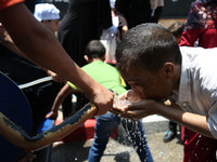 A Palestinian man drinks water to cool off during a demonstration against the siege of Gaza and in solidarity with Al-Aqsa Mosque, in Gaza C...