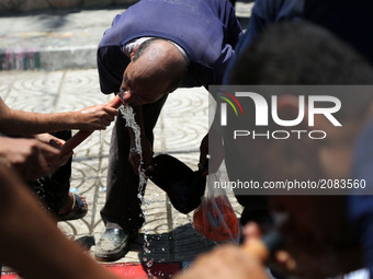 A Palestinian man drinks water to cool off during a demonstration against the siege of Gaza and in solidarity with Al-Aqsa Mosque, in Gaza C...
