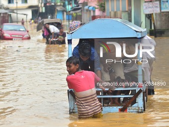 Indian Rickshaw pullers pull commuters to higher ground in a flood area at Dhobinala in Dimapur, India north eastern state of Nagaland on We...