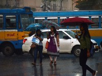 Indian commuters crossing the road during the rain in Kolkata, India on Wednesday , 19th July 2017. (