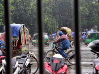 Bangladeshi rickshaw and vehicles drives with passengers on the street during the monsoon rain in Dhaka, Bangladesh On July 19, 2017. (
