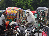 Bangladeshi rickshaw and vehicles drives with passengers on the street during the monsoon rain in Dhaka, Bangladesh On July 19, 2017. (