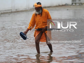 A Sadhu cross flood waters street after heavy rains in Pushkar, India, on August 8, 2014. (