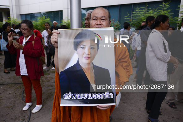 Supporters of ousted former Thai prime minister Yingluck Shinawatra holds a picture Yingluck Shinawatra, while waiting for her arrival at th...