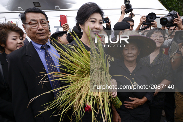 Ousted former Thai Prime Minister Yingluck Shinawatra greets supporters as she arrives at the Supreme Court for a trial on criminal negligen...