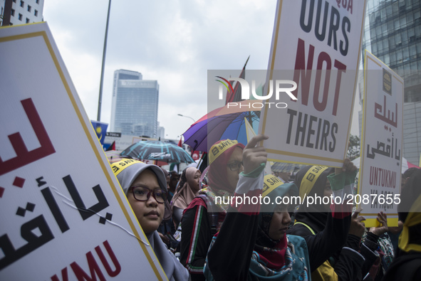 A Muslim woman holds a placard during a protest outside the U.S. Embassy in Kuala Lumpur, Malaysia on Friday, July 21, 2017. A Malaysian Mus...
