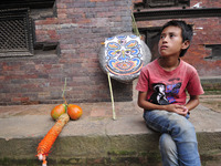 A Kid glancing as Nepalese devotees making straw effigy demon Ghantakarna during the Gathemangal festival celebrated at Bhaktapur, Nepal on...