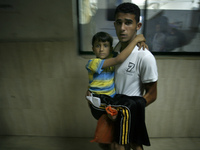 A man carries a Palestinian boy, whom medics said was wounded in an Israeli air strike, at a hospital in Khan Younis in the southern Gaza St...