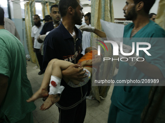 A man carries a Palestinian girl, whom medics said was wounded in an Israeli air strike, at a hospital in Khan Younis in the southern Gaza S...