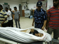 Palestinian policeman checks body whom medics said was killed in an Israeli air strike, at a hospital in Khan Younis in the southern Gaza St...