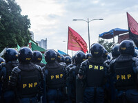Police officers block a section of Roxas Boulevard to prevent the groups from Southern Tagalog to get closer to the US Embassy. Groups from...