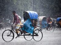 Rickshaw puller carrying passenger when heavy rainfall maid in the Dhaka, Bangladesh on July 23, 2017. (