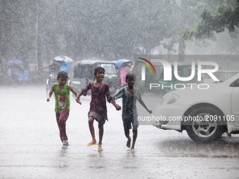 Street children play middle in the street when heavy rainfall maid in the Dhaka, Bangladesh on July 23, 2017. (