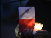 A person holds a copy of Polish Constitution during an anti-government protest - a candle-lit vigil in front of Rzeszow's District Court, on...