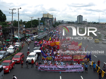 Protesters march towards Congress during a rally coinciding President Rodrigo Duterte's annual State of the Nation Address in Quezon City, n...