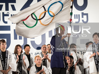 President of Olympic Committee (JOC) Tsunekazu Takeda waves an Olympic flag applauded by Japanese athletes during the Tokyo 2020 flag tour f...