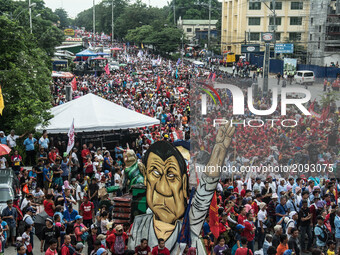 An image of President Rodrigo Duterte stands among thousands of protesters to air their concerns. President Duterte delivers his second Stat...