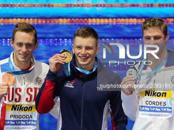 US Kevin Cordes (R), Great Britain's Adam Peaty (C) and Russia's Kirill Prigoda (L) poses with their medals on the podium after the men's 10...